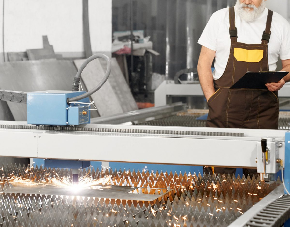 Opérateur supervisant une machine de découpe laser en tôlerie industrielle à Lyon pour usiner une tôle.